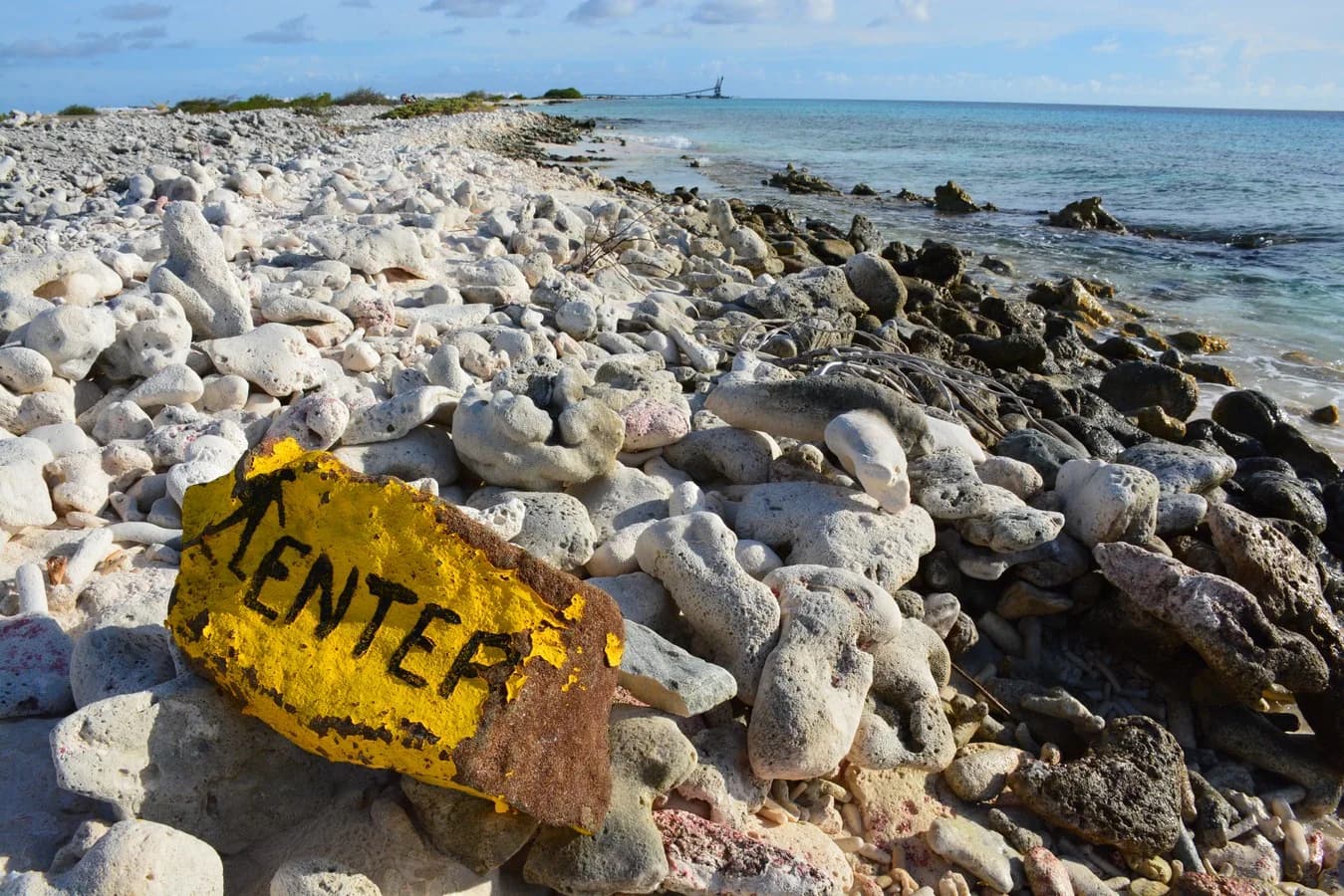 Costa de coral y señal de ingreso al agua en Bonaire